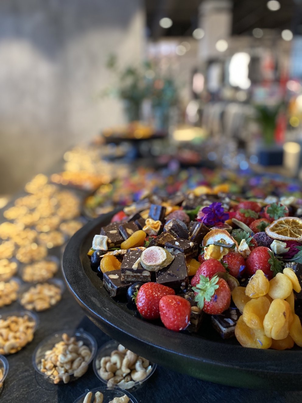 Ferskir og þurrkaðir ávextir, súkkulaði, hnetur og skreytt með blómum.